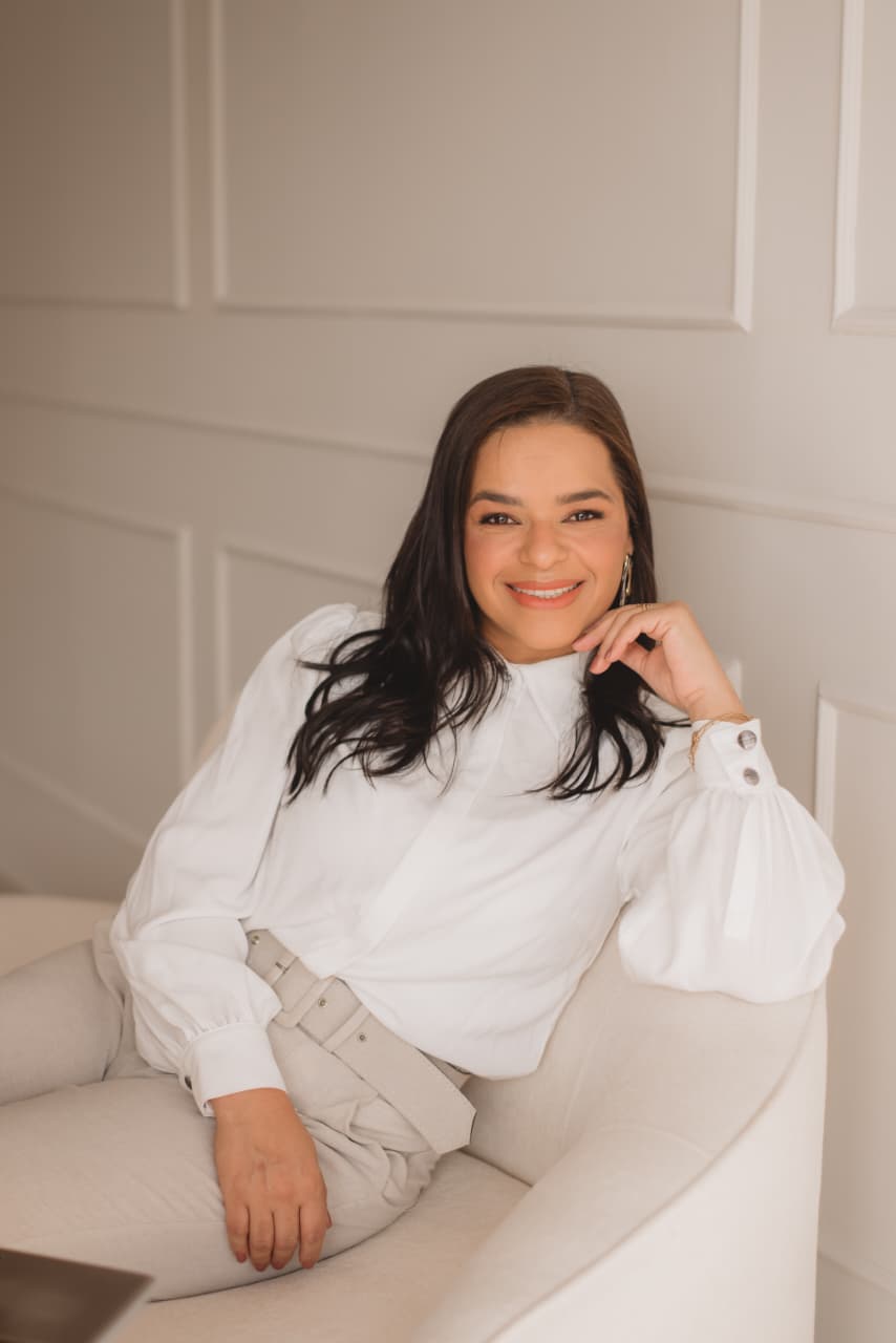 Edi Rodrigues, que conduz o workshop, sentada em uma poltrona com roupa clara